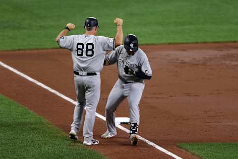 Gio Urshela #29 of the New York Yankees celebrates his two RBI home run in the third inning with third base coach Phil Nevin #88 (Photo by Rob Carr/Getty Images)