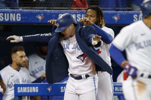 TORONTO, ON – OCTOBER 01: Corey Dickerson #14 of the Toronto Blue Jays is fitted for a jacket by Vladimir Guerrero Jr. #27 as they celebrate Dickerson”u2019s solo home run in the sixth inning of their MLB game against the Baltimore Orioles at Rogers Centre on October 1, 2021 in Toronto, Ontario. (Photo by Cole Burston/Getty Images)