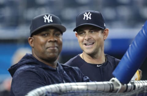 TORONTO, ON - MARCH 30: Manager Aaron Boone #17 of the New York Yankees and hitting coach Marcus Thames #63 (L) look on during batting practice before the start of MLB game action against the Toronto Blue Jays at Rogers Centre on March 30, 2018 in Toronto, Canada. (Photo by Tom Szczerbowski/Getty Images) *** Local Caption *** Aaron Boone;Marcus Thames