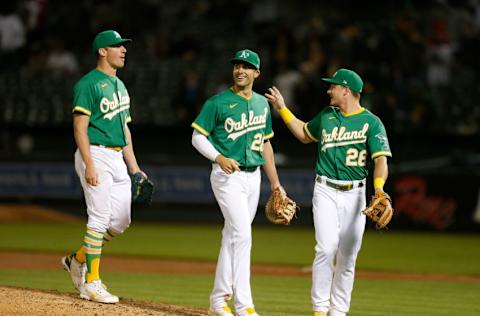 OAKLAND, CALIFORNIA - MAY 27: Starting pitcher Chris Bassitt #40 of the Oakland Athletics celebrates with teammates Matt Olson #28 and Matt Chapman #26 after throwing a complete game against the Los Angeles Angels at RingCentral Coliseum on May 27, 2021 in Oakland, California. The Athletics defeated the Angels 5-0. (Photo by Lachlan Cunningham/Getty Images)