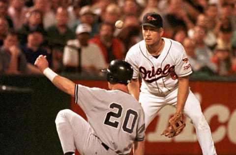 Baltimore Orioles third baseman Cal Ripken (R) watches the ball bounce off third base and over New York Yankee base runner Mike Stanley (20) as Stanley takes third, loading the bases on Yankees Rey Sanches single in the sixth in Baltimore, MD 11 September. AFP PHOTO/Ted MATHIAS (Photo by TED MATHIAS / AFP) (Photo credit should read TED MATHIAS/AFP via Getty Images)