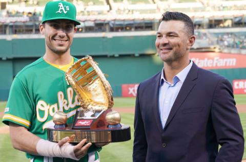 OAKLAND, CA - MARCH 29: Matt Olson #28 of the Oakland Athletics is presented with his Rawlings 2018 Gold Glove Award by former Oakland Athletics gold glover Eric Chavez prior to the start of his game against the Los Angeles Angels of Anaheim at Oakland-Alameda County Coliseum on March 29, 2019 in Oakland, California. (Photo by Thearon W. Henderson/Getty Images)