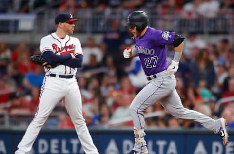 ATLANTA, GA - APRIL 27: Trevor Story #27 of the Colorado Rockies rounds first after hitting a three run home run as Freddie Freeman #5 of the Atlanta Braves reacts in the ninth inning of an MLB game at SunTrust Park on April 27, 2019 in Atlanta, Georgia. (Photo by Todd Kirkland/Getty Images)