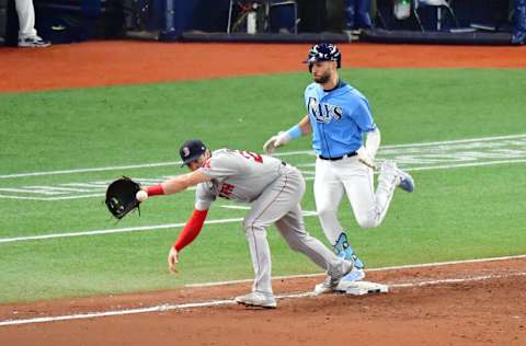 ST. PETERSBURG, FLORIDA - AUGUST 01: Kevin Kiermaier #39 of the Tampa Bay Rays reaches first base ahead of the throw to Bobby Dalbec #29 of the Boston Red Sox in the seventh inning at Tropicana Field on August 01, 2021 in St. Petersburg, Florida. (Photo by Julio Aguilar/Getty Images)