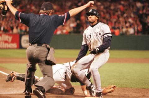 New York Yankees Bernie Williams(R) looks at home plate umpire Mike Reilly(L) after he signaled him safe at home on a wild throw by Baltimore Orioles Todd Zeile in the 8th inning against the Baltimore Orioles in Game 3 of the American League Championship Series at Camden Yards 11 October. The Yankees won 5-2 and lead the series 2-1. AFP PHOTO Jeff Haynes/tac (Photo by JEFF HAYNES / AFP) (Photo credit should read JEFF HAYNES/AFP via Getty Images)