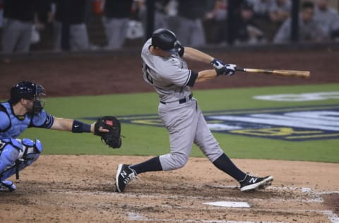 Oct 5, 2020; San Diego, California, USA; New York Yankees second baseman DJ LeMahieu (26) hits a single against the Tampa Bay Rays during the seventh inning in game one of the 2020 ALDS at Petco Park. Mandatory Credit: Orlando Ramirez-USA TODAY Sports