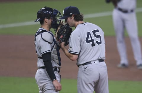 Oct 5, 2020; San Diego, California, USA; New York Yankees catcher Kyle Higashioka (left) talks to starting pitcher Gerrit Cole (45) against the Tampa Bay Rays during the fifth inning in game one of the 2020 ALDS at Petco Park. Mandatory Credit: Orlando Ramirez-USA TODAY Sports