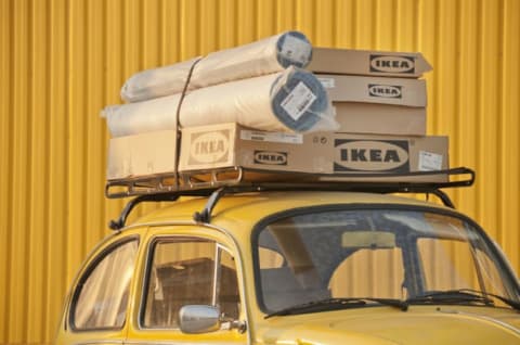 A car topped with boxes of IKEA furniture