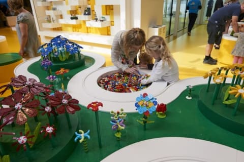 Children build LEGO flowers to plant in a special LEGO meadow.