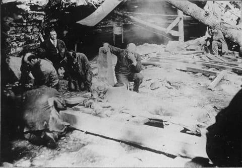 Workers pray over the exhumed body of Floyd Collins.