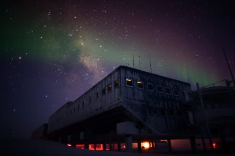 The Milky Way and aurora australis illuminate the Amundsen-Scott South Pole Station in winter.