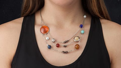 A woman wearing the solar system necklace